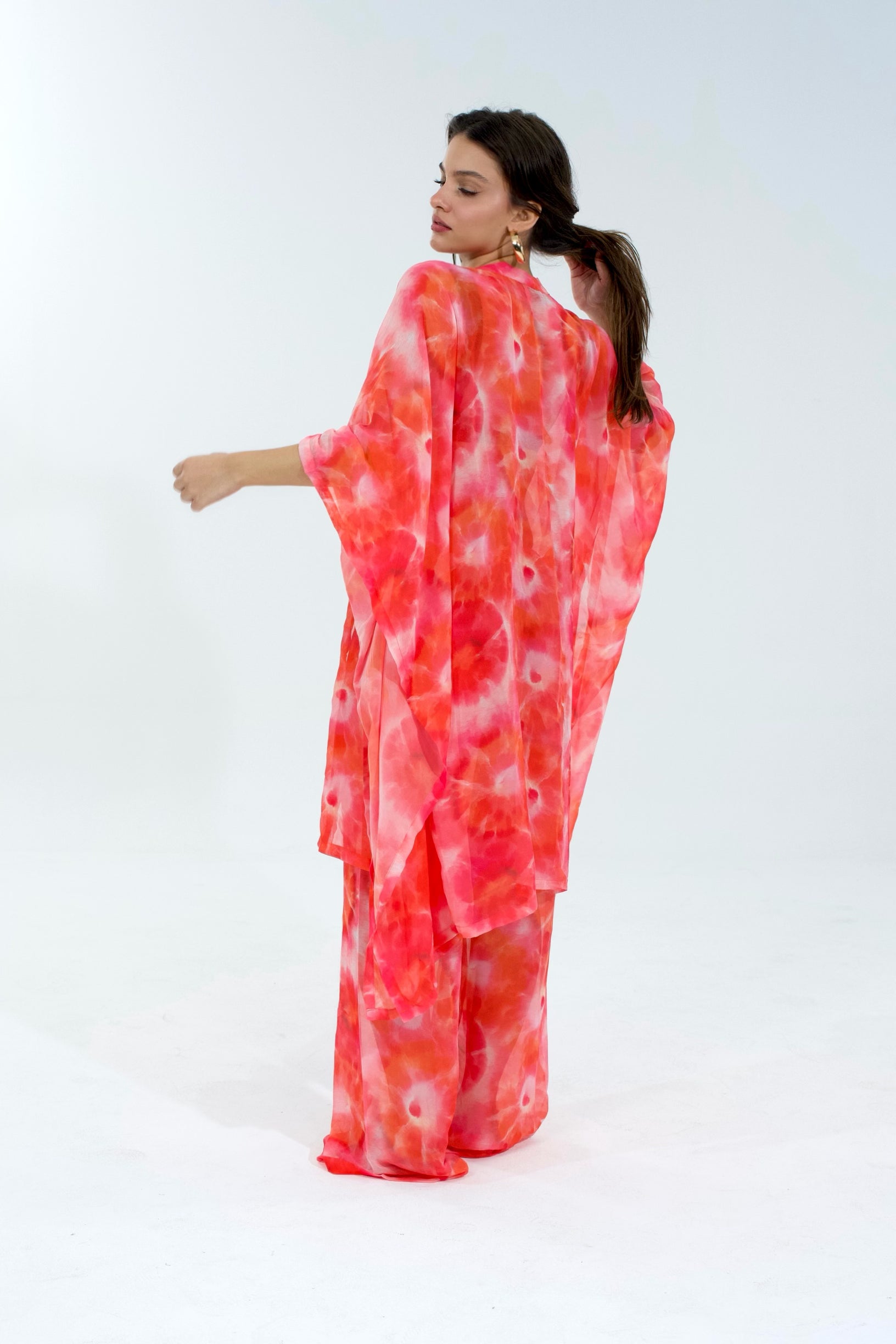 Woman wearing a red and white patterned dress on a white background