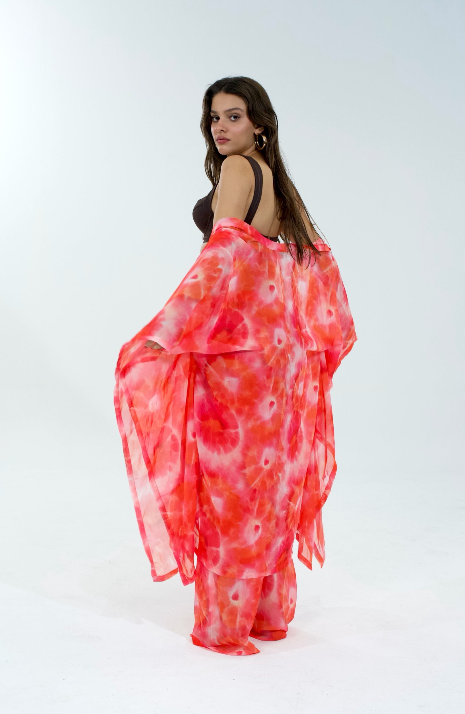 Woman wearing a red and white patterned dress on a white background